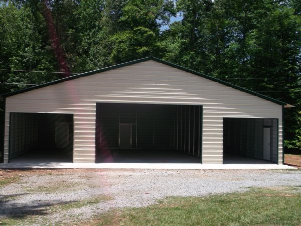 A fully enclosed standard barn metal building on a concrete pad.